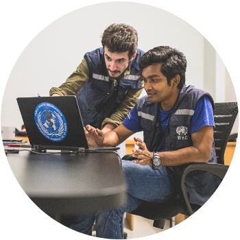 Two male WHO staff looking at a computer.